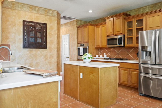3207 Summerwind Ct, Pearland, TX 77584 - kitchen featuring stainless steel appliances, a kitchen island, light tile patterned flooring, brown cabinetry, and glass insert cabinets