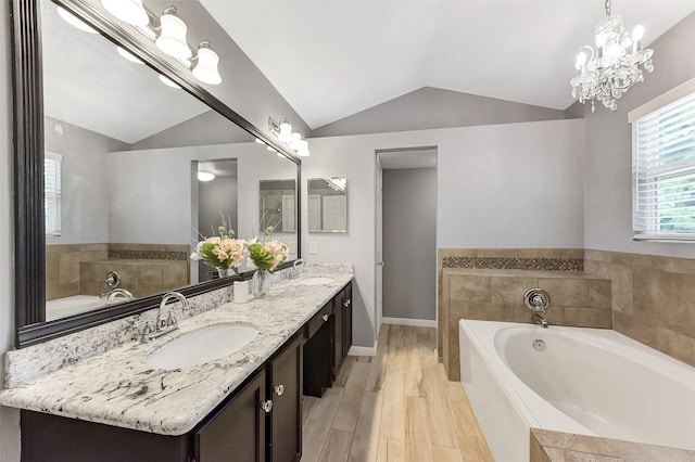 17214 Palm Falls Ct, Houston, TX 77095 - bathroom featuring lofted ceiling, double vanity, a bath, and a chandelier