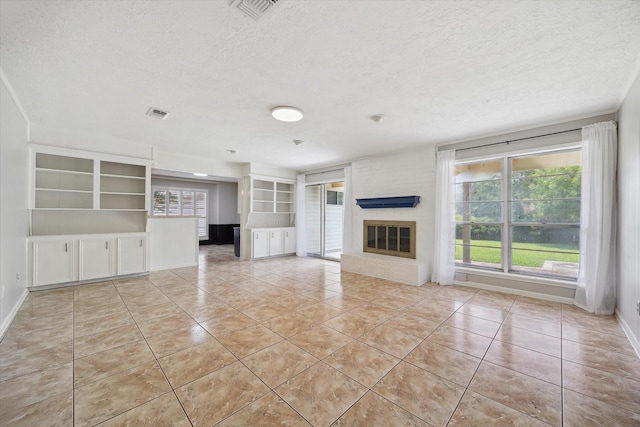 1003 Kemberton Dr, Houston, TX 77062 - unfurnished living room featuring a textured ceiling, light tile patterned floors, and a fireplace