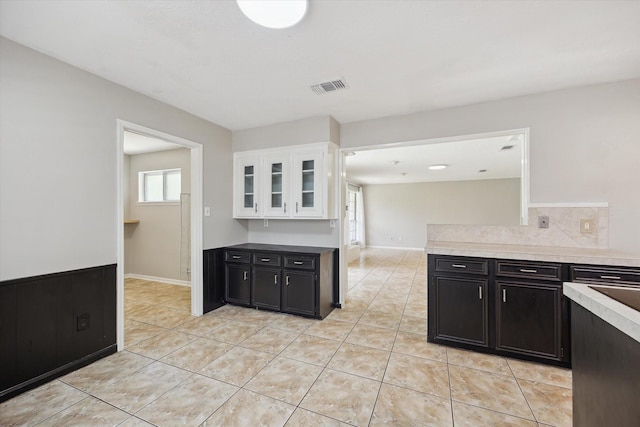 1003 Kemberton Dr, Houston, TX 77062 - kitchen featuring white cabinetry, light tile patterned flooring, dark cabinetry, and glass insert cabinets
