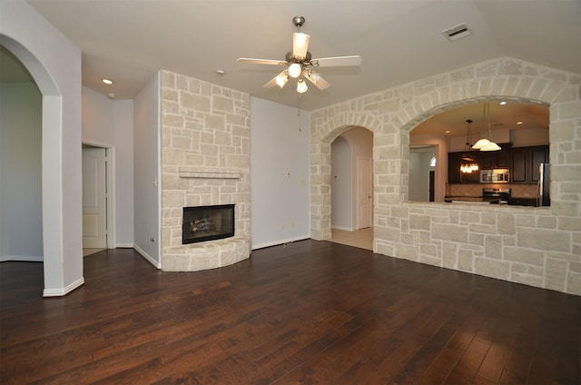 21514 Colton Cove Dr, Houston, TX 77095 - unfurnished living room featuring a ceiling fan, hardwood / wood-style flooring, a stone fireplace, and arched walkways