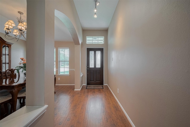 21619 Oakcreek Ct, Katy, TX 77450 - foyer entrance featuring wood finished floors, arched walkways, track lighting, and a chandelier