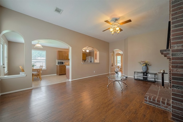 21619 Oakcreek Ct, Katy, TX 77450 - living room with a ceiling fan, healthy amount of natural light, arched walkways, and light wood-style floors