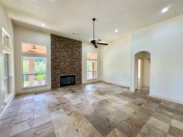 8110 Hideaway Run Way, Spring, TX 77389 - unfurnished living room with stone tile flooring, healthy amount of natural light, arched walkways, ceiling fan, and recessed lighting