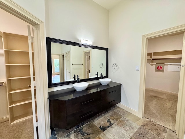 8110 Hideaway Run Way, Spring, TX 77389 - bathroom featuring double vanity, a walk in closet, and stone finish floors