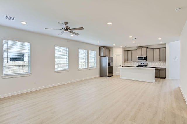 19367 Poppy Village Cir, Magnolia, TX 77355 - unfurnished living room with a ceiling fan, light wood-style floors, and recessed lighting