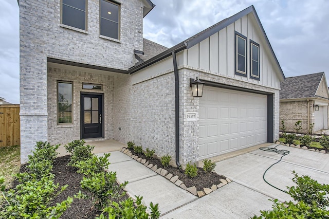 19367 Poppy Village Cir, Magnolia, TX 77355 - view of front of home featuring board and batten siding, a garage, brick siding, and roof with shingles