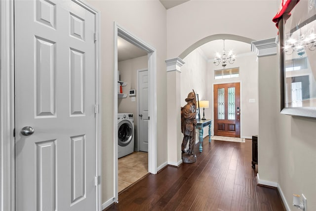423 Carson Ridge Dr, Spring, TX 77386 - foyer entrance featuring washer / clothes dryer, a chandelier, arched walkways, ornamental molding, and dark wood finished floors