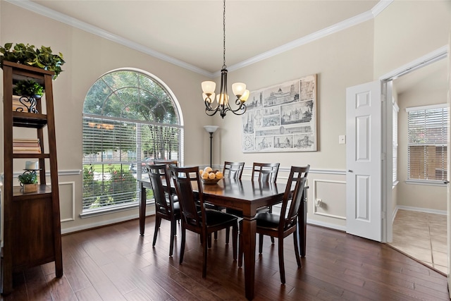 423 Carson Ridge Dr, Spring, TX 77386 - dining space featuring crown molding, dark wood-type flooring, a chandelier, a wainscoted wall, and a decorative wall