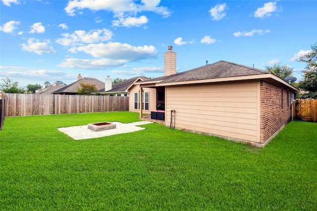 423 Carson Ridge Dr, Spring, TX 77386 - back of house featuring a fire pit, a fenced backyard, brick siding, a chimney, and roof with shingles