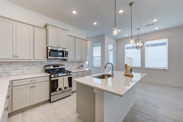 21010 Garden Palm Dr, Cypress, TX 77433 - kitchen featuring stainless steel appliances, tasteful backsplash, light wood finished floors, an island with sink, and recessed lighting