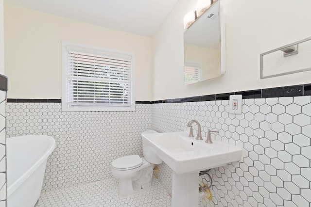 6234 Shadow Crest St, Houston, TX 77074 - bathroom featuring a wainscoted wall, a freestanding bath, tile walls, and tile patterned floors
