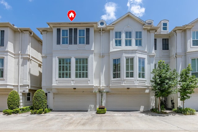 1908 Greenwich Place Dr, Houston, TX 77019 - view of front facade with a garage, driveway, and stucco siding