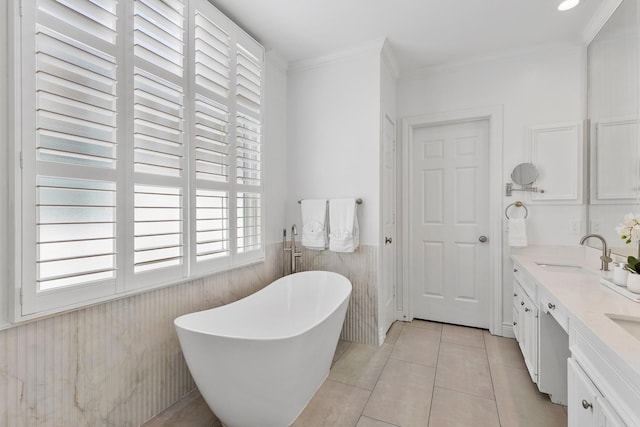 1908 Greenwich Place Dr, Houston, TX 77019 - bathroom featuring a freestanding bath, a wainscoted wall, double vanity, tile patterned floors, and ornamental molding