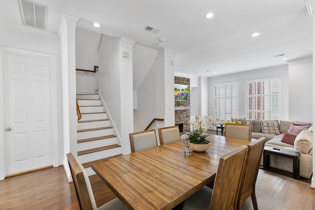 1908 Greenwich Place Dr, Houston, TX 77019 - dining space featuring wood finished floors, crown molding, recessed lighting, stairway, and decorative columns