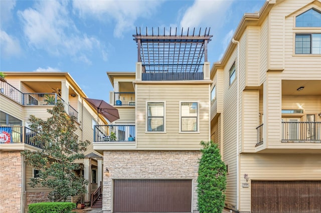 2043 W 14th 1/2 St, Houston, TX 77008 - view of front of house with a balcony, an attached garage, stone siding, and a metal roof