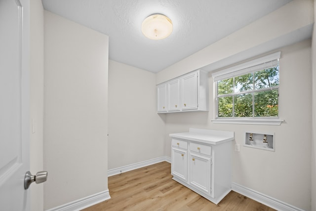 3503 Arbor Terrace Ct, Spring, TX 77388 - washroom featuring cabinet space, light wood-type flooring, hookup for a washing machine, and a textured ceiling