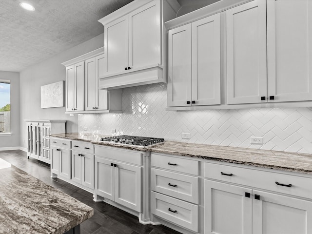3723 Kerr Commons Ln, Houston, TX 77059 - kitchen with a textured ceiling, backsplash, white cabinets, stainless steel gas stovetop, and light stone counters