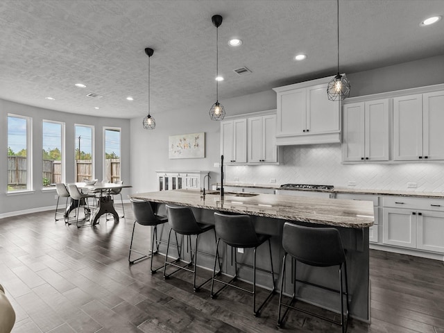3723 Kerr Commons Ln, Houston, TX 77059 - kitchen featuring a textured ceiling, recessed lighting, tasteful backsplash, dark wood finished floors, and white cabinetry