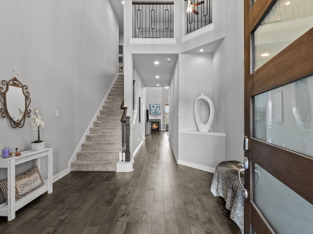 3723 Kerr Commons Ln, Houston, TX 77059 - entrance foyer featuring a high ceiling, a lit fireplace, stairs, and dark wood-type flooring