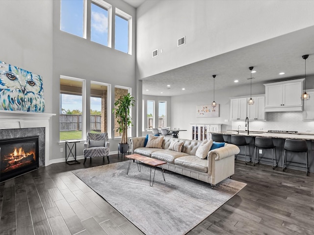 3723 Kerr Commons Ln, Houston, TX 77059 - living room featuring a tiled fireplace, dark wood finished floors, a high ceiling, and recessed lighting
