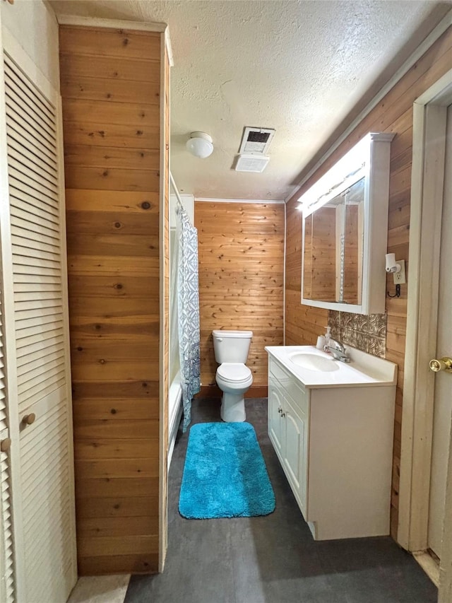 1410 W Pavillion St, Woodville, TX 75979 - bathroom featuring vanity, wooden walls, shower / tub combo, and a textured ceiling