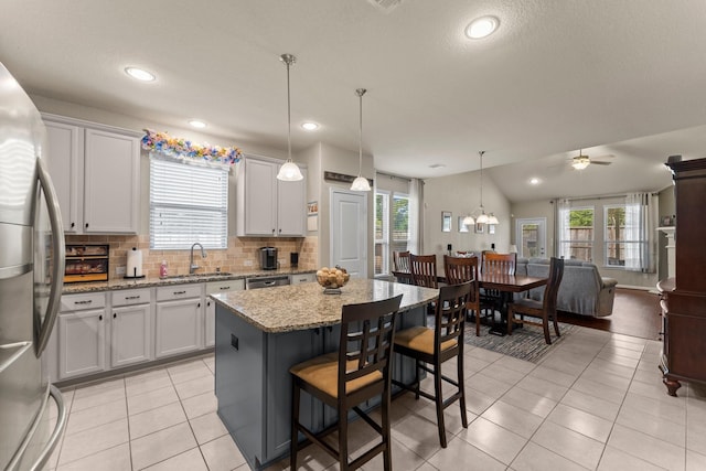 23707 Pennington Hills Dr, Spring, TX 77389 - kitchen featuring stainless steel appliances, open floor plan, light tile patterned flooring, ceiling fan, and plenty of natural light