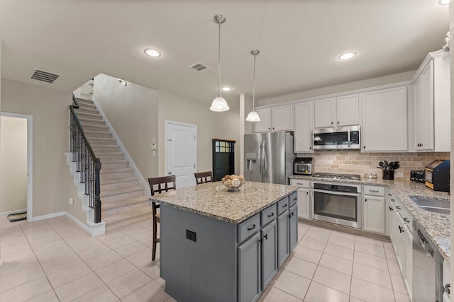 23707 Pennington Hills Dr, Spring, TX 77389 - kitchen featuring appliances with stainless steel finishes, light tile patterned floors, decorative backsplash, white cabinetry, and recessed lighting