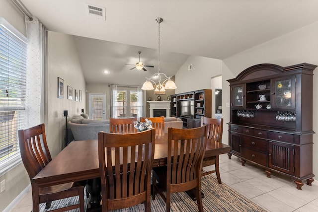 23707 Pennington Hills Dr, Spring, TX 77389 - dining room with lofted ceiling, ceiling fan, light tile patterned flooring, a fireplace, and a chandelier