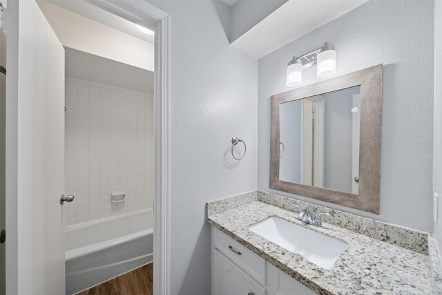 23206 Goodfellow Dr, Spring, TX 77373 - bathroom featuring vanity, wood finished floors, bathing tub / shower combination, and a textured wall
