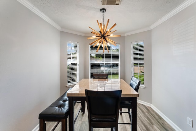 2410 Prides Crossing Rd, Houston, TX 77067 - dining space featuring a chandelier, light wood-style flooring, a textured ceiling, and ornamental molding