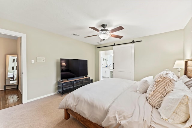 115 Heather Ln, Conroe, TX 77385 - bedroom with a barn door, carpet floors, a ceiling fan, and connected bathroom
