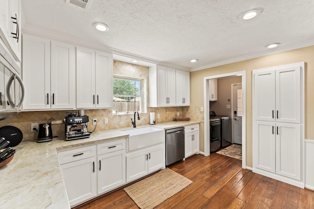 115 Heather Ln, Conroe, TX 77385 - kitchen featuring dishwasher, washing machine and clothes dryer, white cabinets, backsplash, and recessed lighting