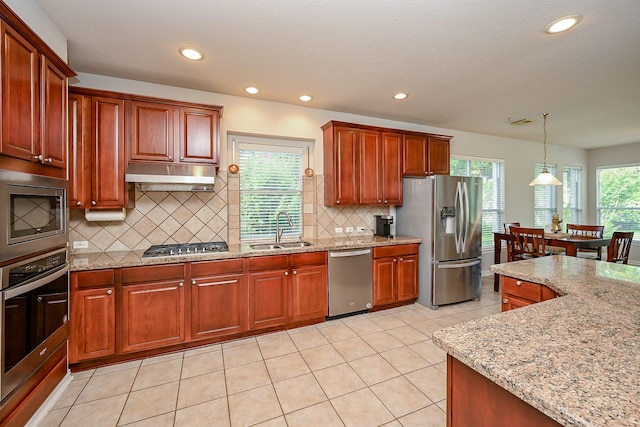 806 Spring Mist Ct, Sugar Land, TX 77479 - kitchen with appliances with stainless steel finishes, under cabinet range hood, recessed lighting, tasteful backsplash, and light stone countertops