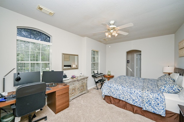 806 Spring Mist Ct, Sugar Land, TX 77479 - bedroom with arched walkways, light carpet, a desk, and a ceiling fan