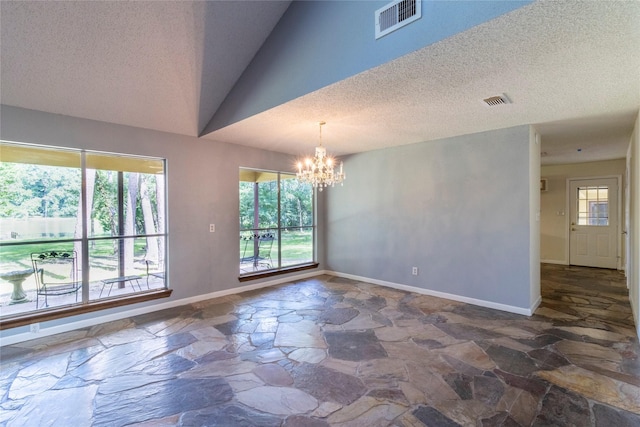 15823 Stagecoach Rd, Stagecoach, TX 77355 - unfurnished room with stone floors, a chandelier, a textured ceiling, and vaulted ceiling