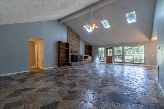 15823 Stagecoach Rd, Stagecoach, TX 77355 - unfurnished living room with stone floors, high vaulted ceiling, a skylight, a brick fireplace, and beam ceiling