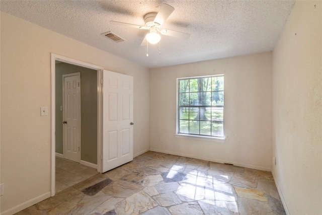 15823 Stagecoach Rd, Stagecoach, TX 77355 - unfurnished bedroom featuring a textured ceiling, ceiling fan, and stone finish floors