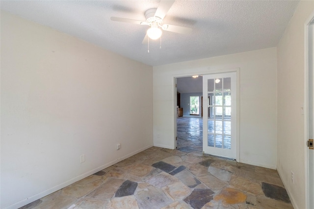 15823 Stagecoach Rd, Stagecoach, TX 77355 - spare room featuring stone flooring, a textured ceiling, and ceiling fan