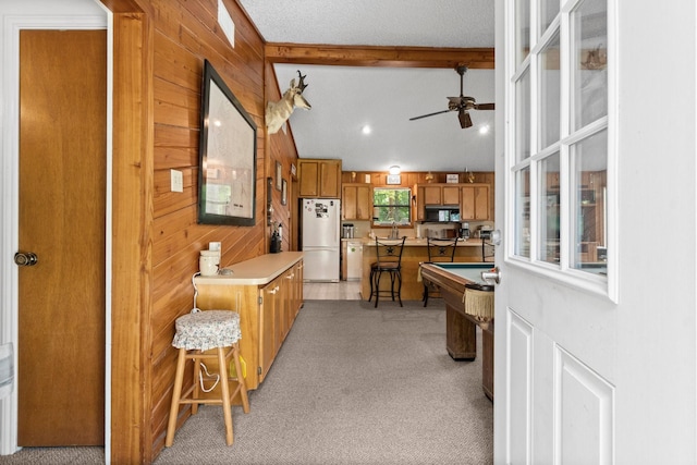 31 N Lakeview Dr, Point Blank, TX 77364 - kitchen with freestanding refrigerator, a ceiling fan, light colored carpet, wood walls, and brown cabinetry