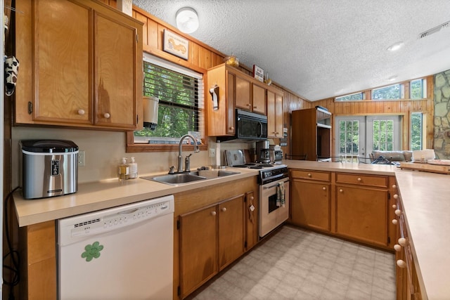 31 N Lakeview Dr, Point Blank, TX 77364 - kitchen featuring white appliances, light countertops, a textured ceiling, light flooring, and vaulted ceiling