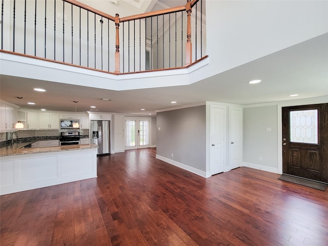 2608 Arlington St, Houston, TX 77008 - unfurnished living room with dark wood-style floors, crown molding, a high ceiling, and recessed lighting