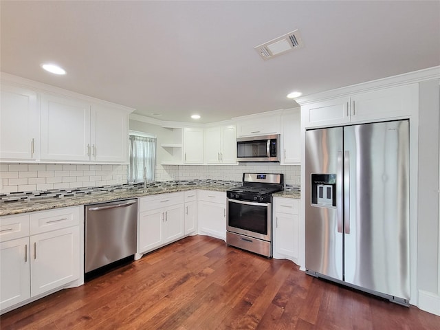 2608 Arlington St, Houston, TX 77008 - kitchen featuring stainless steel appliances, open shelves, backsplash, white cabinets, and dark wood finished floors