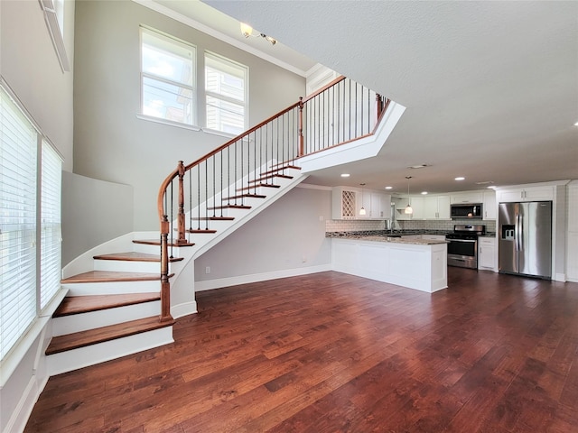 2608 Arlington St, Houston, TX 77008 - unfurnished living room with stairway, dark wood finished floors, recessed lighting, ornamental molding, and a towering ceiling