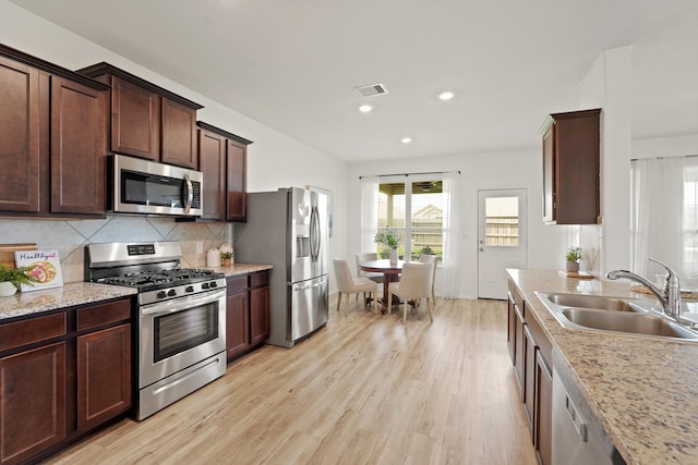 18402 Hilltop Climb Dr, Hockley, TX 77447 - kitchen with stainless steel appliances, light wood-style flooring, healthy amount of natural light, decorative backsplash, and recessed lighting