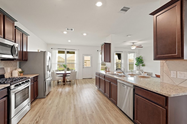 18402 Hilltop Climb Dr, Hockley, TX 77447 - kitchen with stainless steel appliances, light wood-style flooring, backsplash, light stone countertops, and recessed lighting