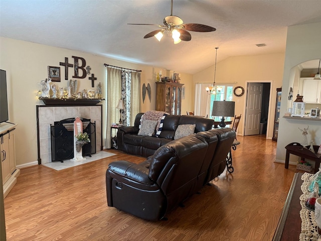 343 Lake View Dr, Montgomery, TX 77356 - living room with ceiling fan, lofted ceiling, light wood-style floors, a chandelier, and a fireplace