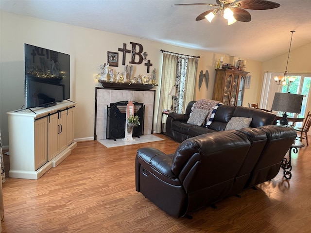 343 Lake View Dr, Montgomery, TX 77356 - living room with a chandelier, ceiling fan, light wood-style floors, vaulted ceiling, and a tile fireplace