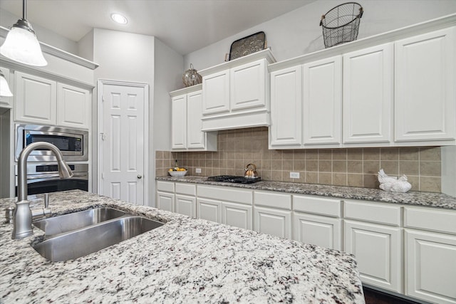 3030 Rabbit Brush Ln, Manvel, TX 77578 - kitchen with stainless steel appliances, white cabinetry, tasteful backsplash, decorative light fixtures, and light stone countertops