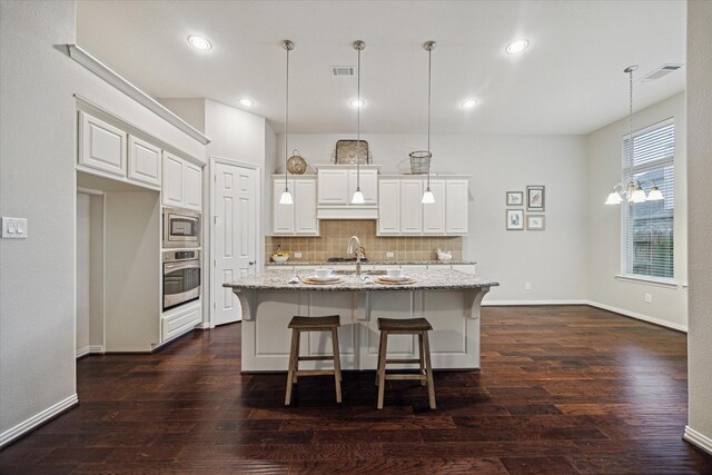 3030 Rabbit Brush Ln, Manvel, TX 77578 - kitchen with stainless steel appliances, decorative backsplash, light stone counters, white cabinetry, and recessed lighting
